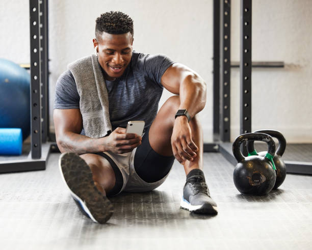 NMN ingredient dosage - a man on the floor of a gym looking at his phone